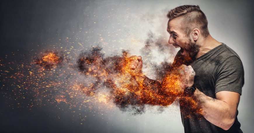 Excited man in fighting gesture with fists on fire. Rage concept. Heated fight. Aggressive behaviour concept